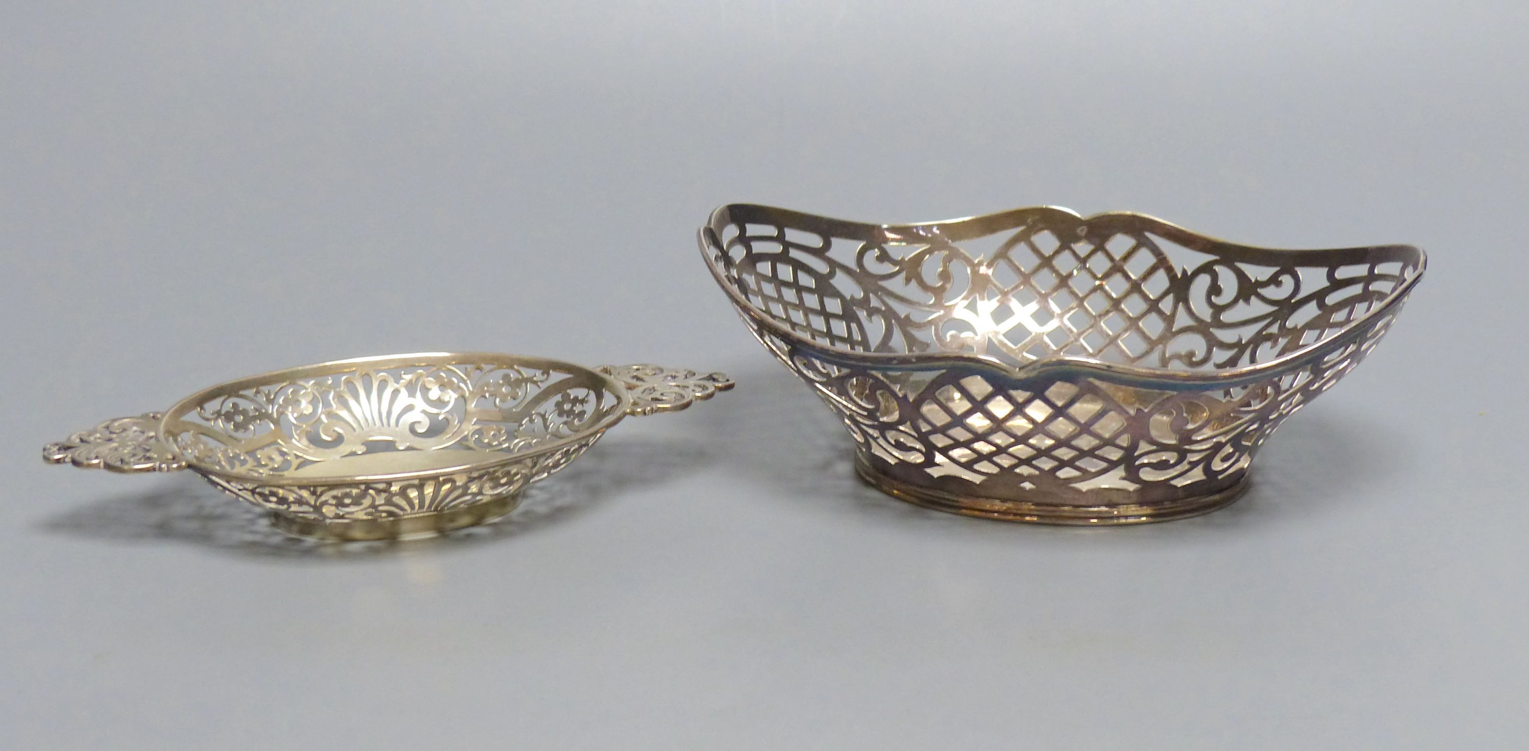 An Edwardian silver oval bon bon dish with pierced flower and scroll decoration and a Dutch white metal sweetmeat basket